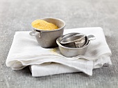 Metal Measuring Cups; One with Corn Meal
