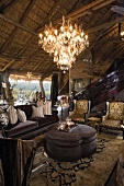 A Rococo-style furnished living room with gilded chandeliers in an African hut