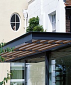 Traditionelle Villa mit Sonnenschutzdach aus Holzlamellen