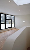 Empty living room with recessed downlights and large window in a contemporary building