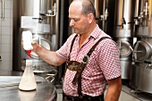 A brewer measuring the fermentation temperature