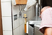A brewer measuring the density of beer with a hydrometer