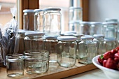 Various empty jam jars in front of a kitchen window
