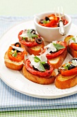 Crostini (toasted bread topped with tomatoes, Parmesan cheese and olives)