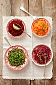 Four salads: red cabbage with walnuts, peas with dill, butter and breadcrumbs, carrots with apple, grated beetroot with horseradish
