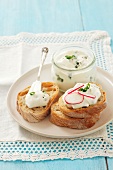 Slices of bread topped with chive quark and radishes