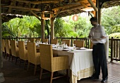 Restaurant staff member giving the finishing touches to a set table