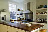 Kitchen with kitchen island, stainless steel appliances and open shelving wall