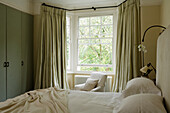 Bedroom with large windows and heavy curtains