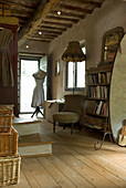 Country-style hallway with wooden floor, dressmaker's dummy and antique furniture