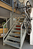 Metal staircase with banister and bicycle hanging from it in a living room