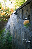 A shower on a stone wall in a garden