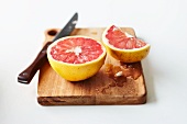Cut pink grapefruit on chopping board