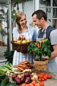 A couple with freshly harvested organic vegetables and apples