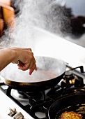A man stirring a pan on a hob