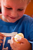 A little boy painting an Easter egg