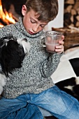 Junge mit Hund trinkt Kakao