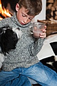 A boy and a dog drinking cocoa