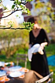 A woman approaching a table laid in a garden