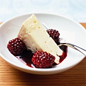 A slice of cheese with blackberry sauce