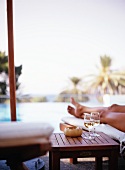 Two glasses of white wine on side table by swimming pool