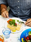 A man eating fish with rice and salad
