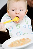 A baby eating mush