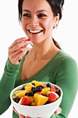 A woman eating fruit salad