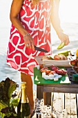 A woman preparing food in front of a jetty