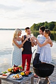 People toasting with champagne at a barbecue party by a sea