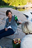 Two women having a picnic by the sea in Stockholm (Sweden)