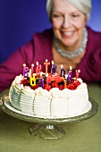 A woman looking at a birthday cake