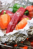 Peppers wrapped in tin foil on a grill
