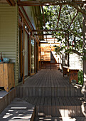 Wooden terrace with pergola, bench in the shade of trees