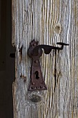 Old, rusty lock and handle on wooden door