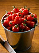 Lots of plum tomatoes in a bucket