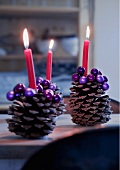 Large pine cones decorated with purple beads used as candlesticks