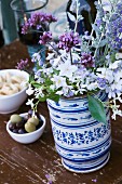 Garden flowers in painted ceramic vase on wooden table