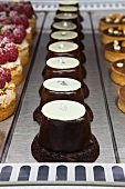 Chocolate Eclipse Pastries in a Display; Raspberry and Chocolate Tarts