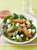 Spinach Salad with Pear Slices, Walnuts and Feta Cheese on a Plate with Fork