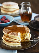 Stack of Buttermilk Pancakes with Syrup and Powdered Sugar; Bite Taken Out
