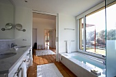 Bright bathroom with floor-to-ceiling window, sliding door and terracotta tiles