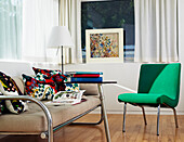 Sofa mit bunten Kissen und grünem Stuhl im modernen Wohnzimmer