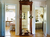 Antique, full-length mirror with ornate frame in hallway between bedroom and guest room