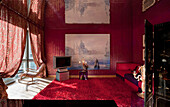 Opulent living room with red carpet and large painting of Venice