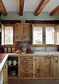 Country-style kitchen with wooden cupboards and ceiling beams