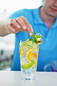 Garnishing vodka drink with mint