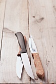 Three steak knives on a wood background
