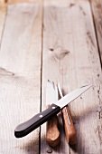 Three steak knives on a wood background