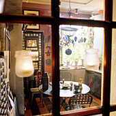 View through window to small kitchen with vintage decorations and pendant lights